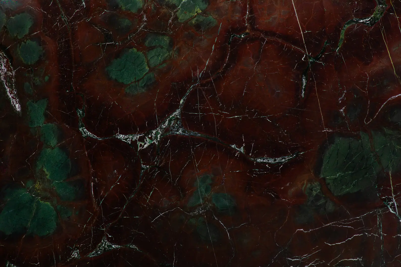 Ocean Red Marble slab featuring deep crimson tones with green and white veining. A rare Italian stone ideal for luxury interiors and statement walls.