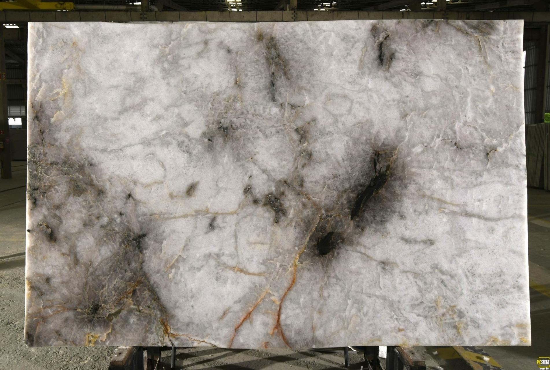 Crystallo Spectra Quartzite slab featuring smoky grey crystals with olive green mineral pockets and rustic beige veining in an exotic Brazilian quartzite.