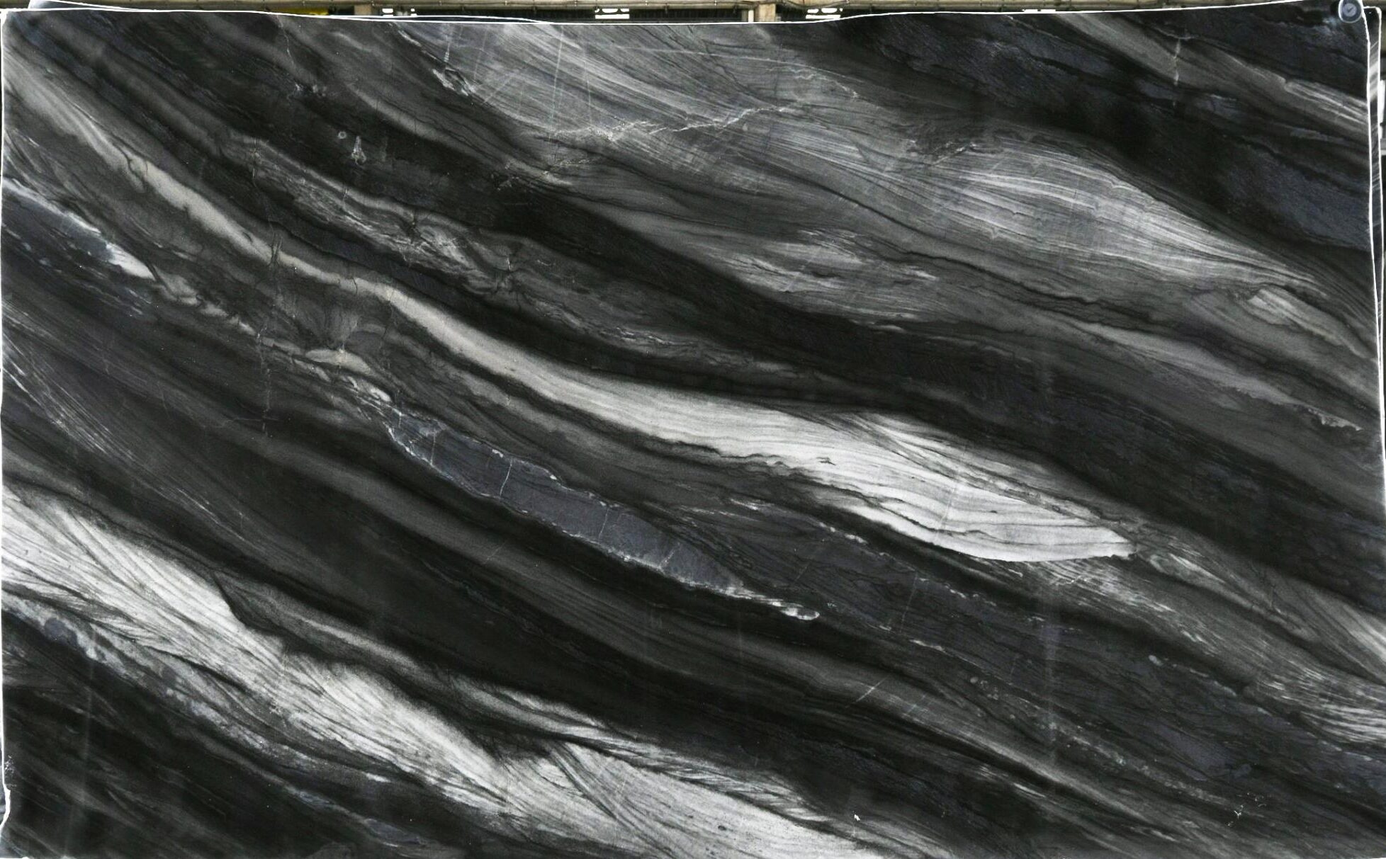 Black Raj quartzite slab with charcoal and silver-gray diagonal banding, leathered finish