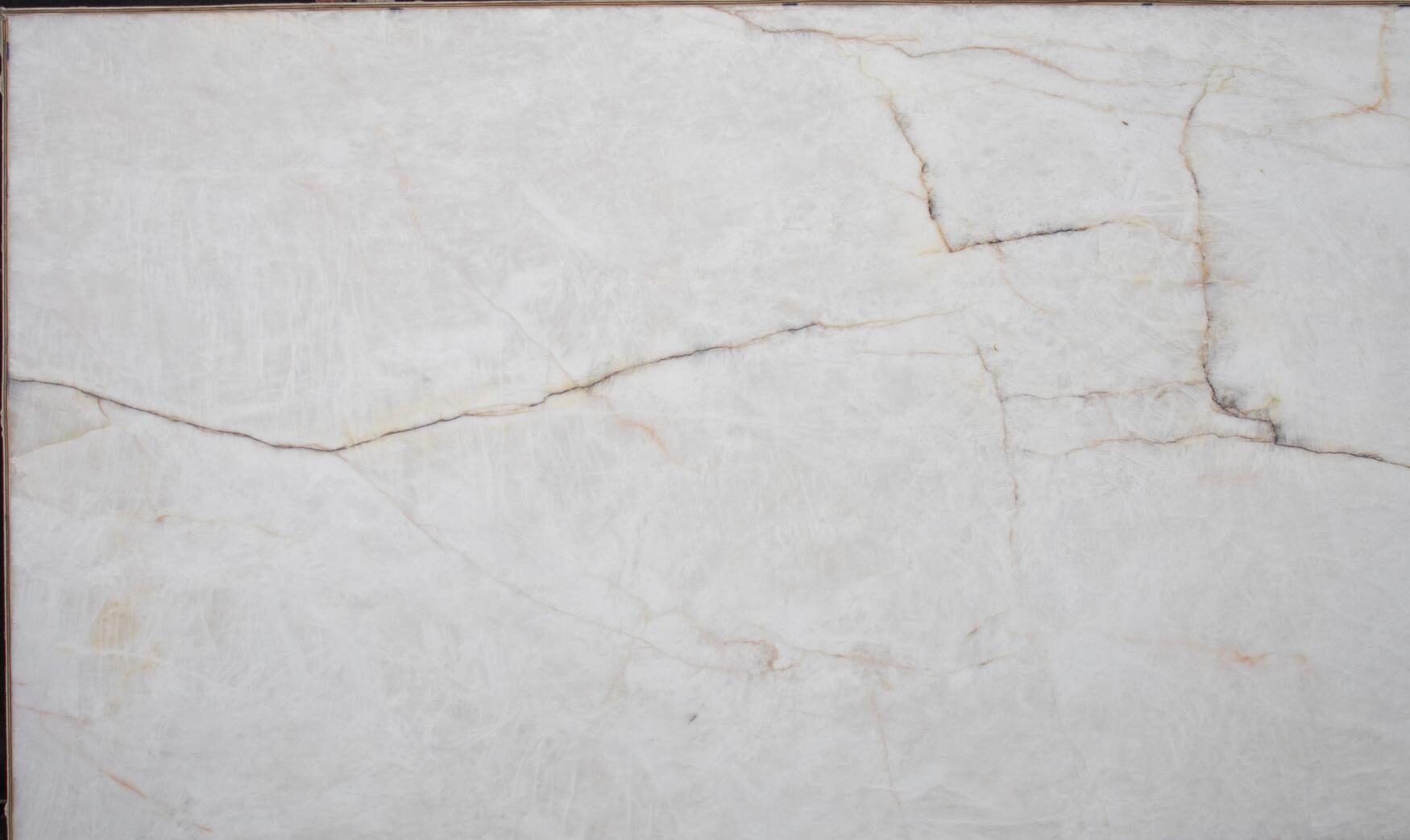 Cristallo Iluminato quartzite slab with bright white background and fine amber veining, honed finish