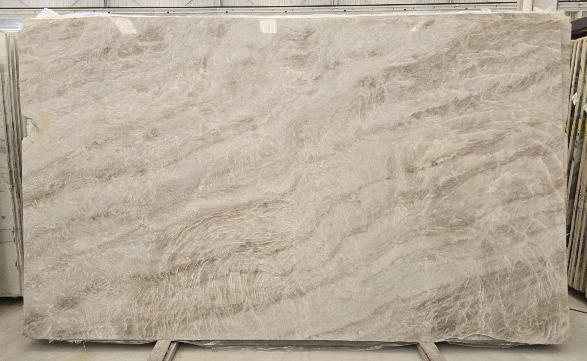 Naica quartzite slab with cream and taupe cloudlike movement, honed finish